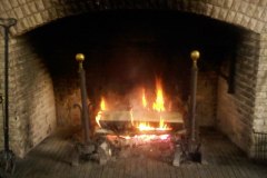The Great Hall fireplace (burning 4-foot logs)